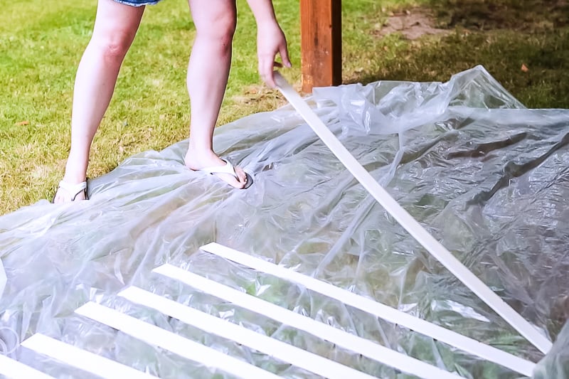 window blinds laid out on plastic tarp before painting