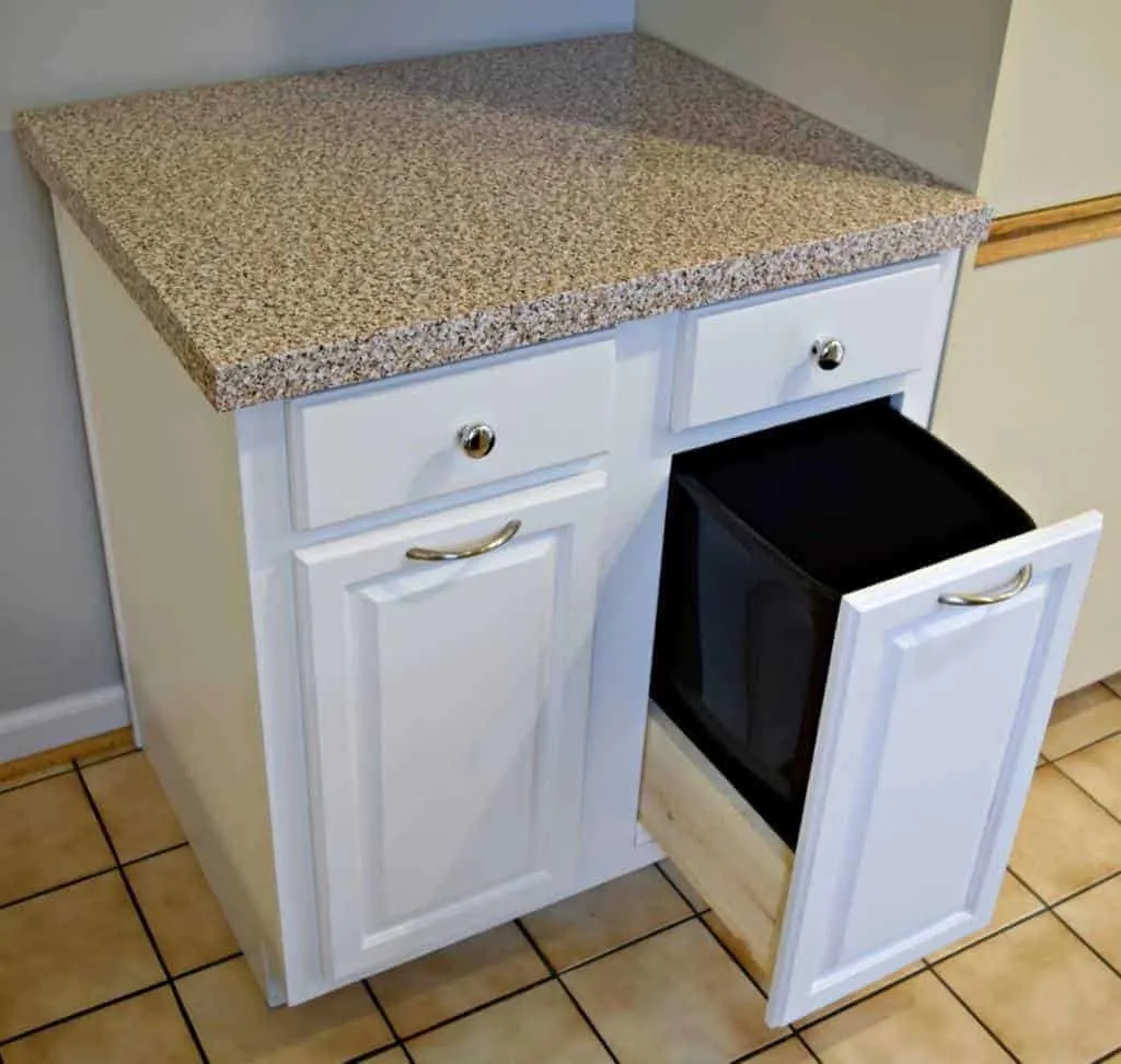 kitchen cabinet with pull out trash can and contact paper countertop