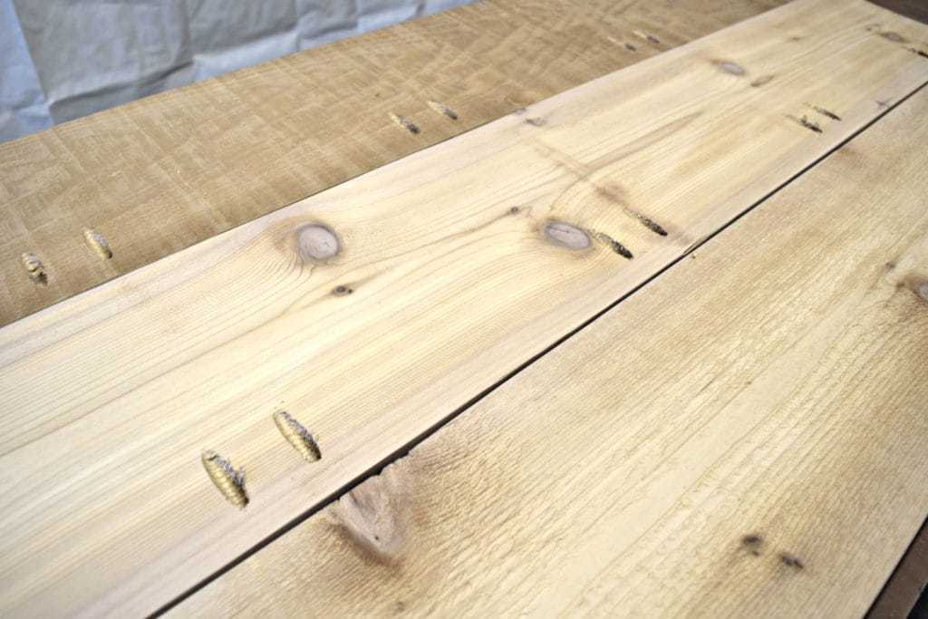 Attach the cedar boards of the outdoor storage bench lid together with pocket hole screws - www.thehandymansdaughter.com