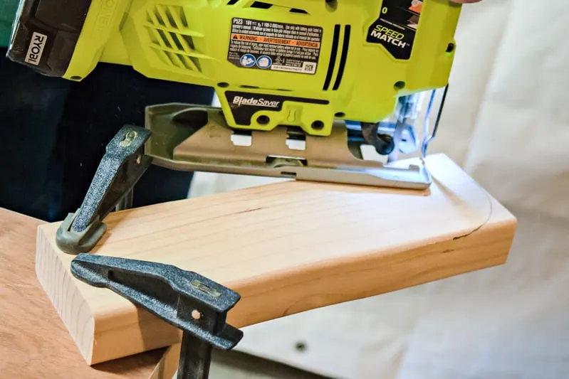 cutting a curve on the ends of the DIY cornhole board leg with a jigsaw