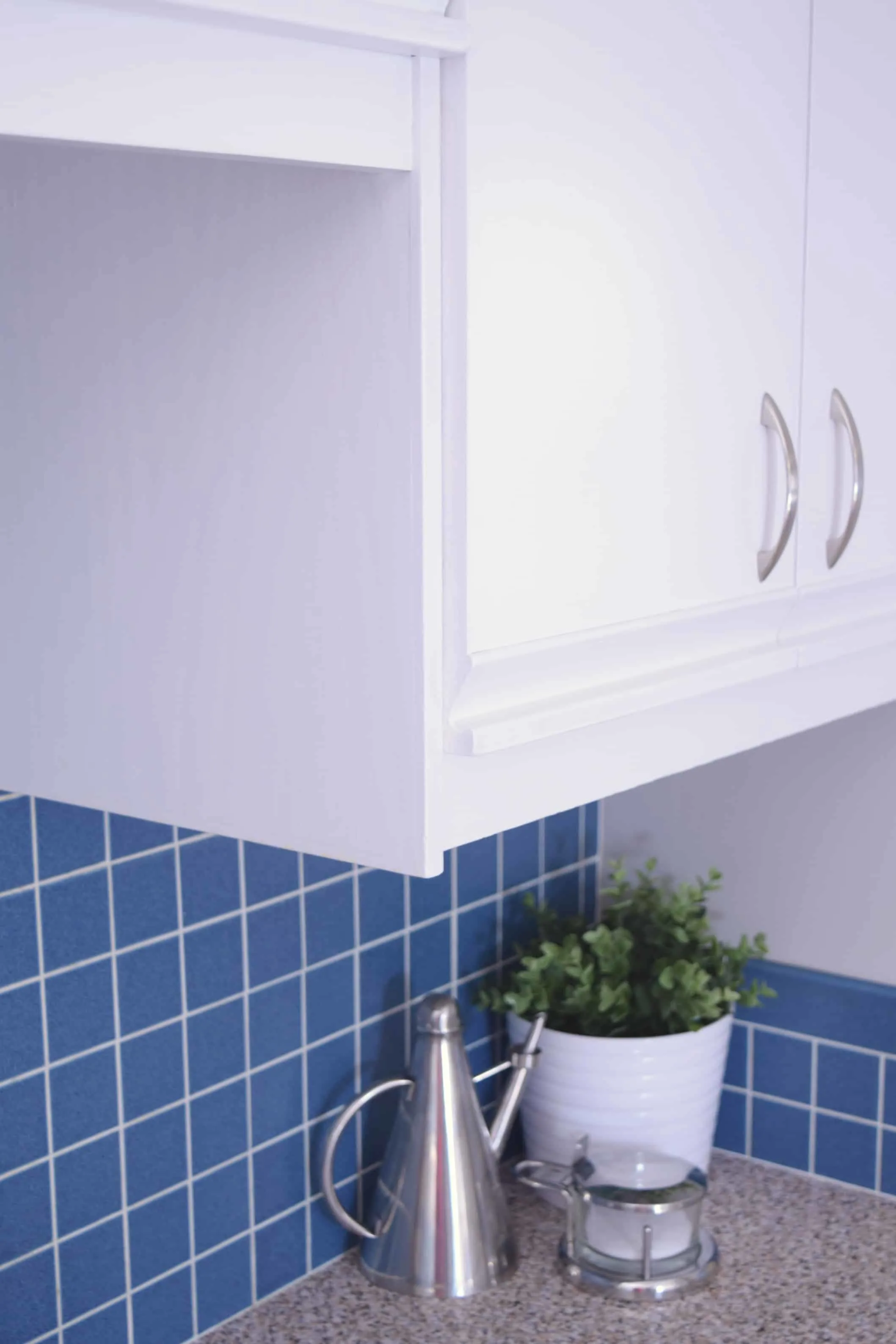 white painted kitchen cabinets with blue backsplash