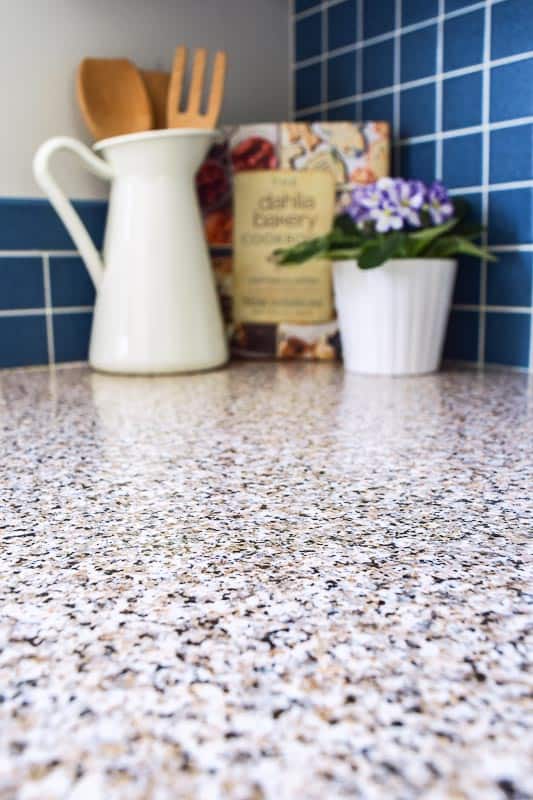 close up of contact paper counter top with vase and cookbook in background