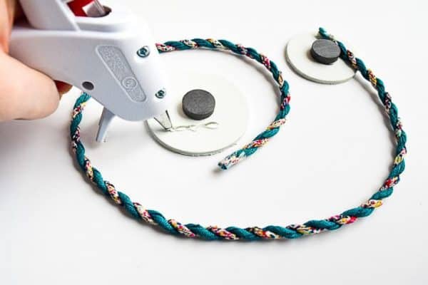 length of cord being glued to two circles with magnets