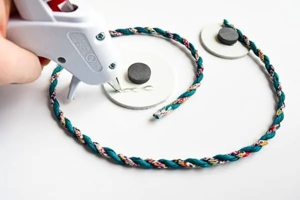 length of cord being glued to two circles with magnets