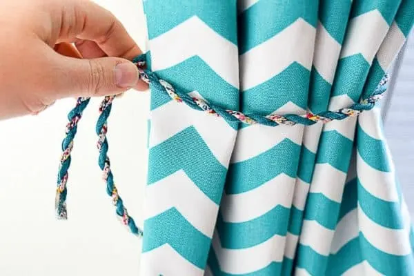 chevon pattern curtain with length of cord being measured for magnetic curtain tie back