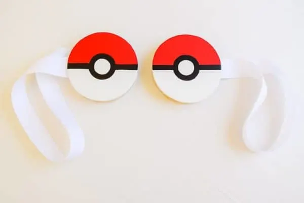 two magnetic curtain tie backs with pokeballs painted on white wooden circles