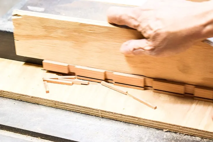 cutting a small groove out of a piece of wood on a table saw