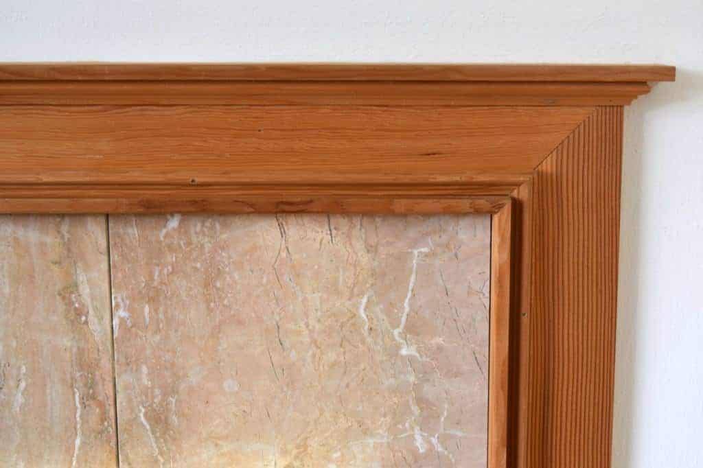 orange oak wood trim around peach marble fireplace tile