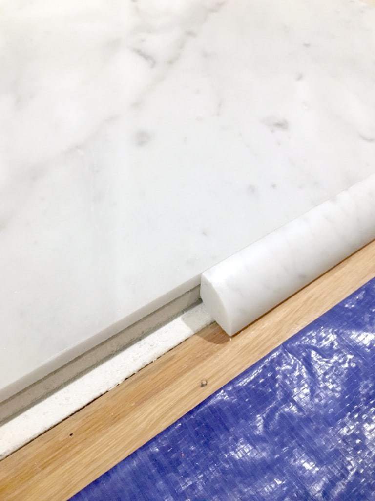 marble tile and quarter round trim for fireplace hearth