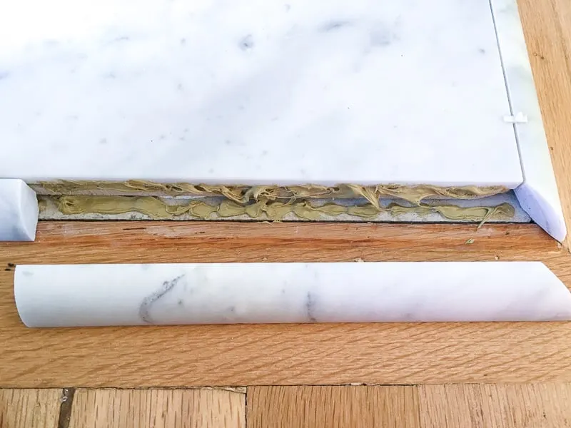 Liquid Nails for marble applied to fireplace hearth quarter round tile