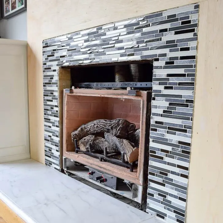 glass and stone mosaic tile around fireplace opening
