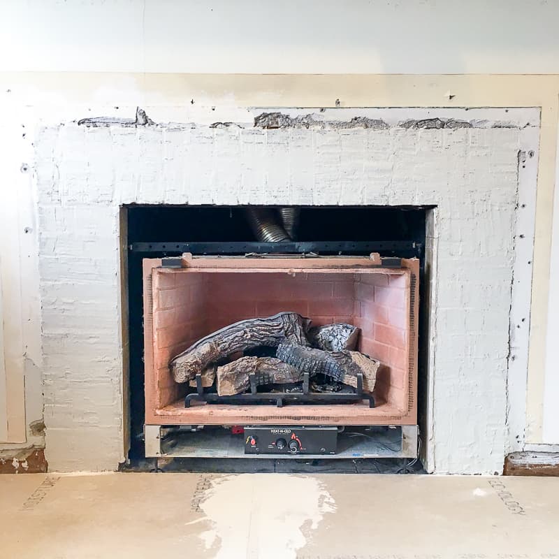 brick fireplace smoothed over with a coat of thin set mortar in preparation for new fireplace tile