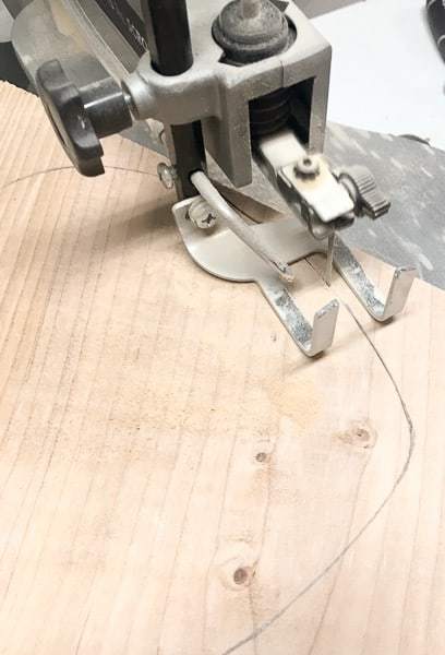 cutting out wooden heart with a scroll saw