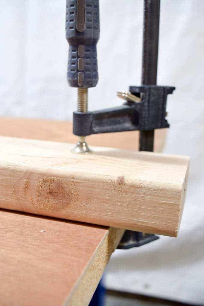 2x4 board clamped to workbench top