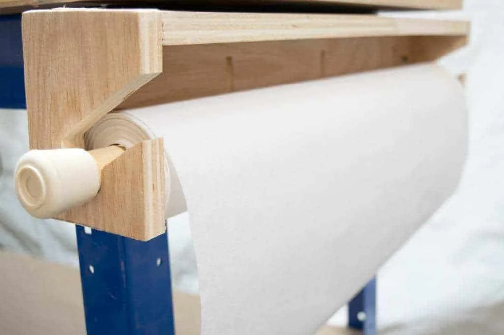 kraft paper roll holder bolted to side of workbench