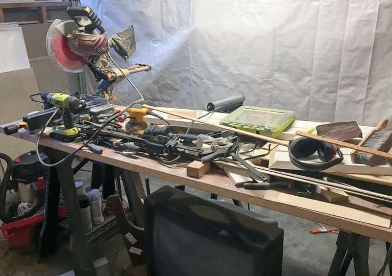 workbench made with an old door and sawhorses, covered in tools