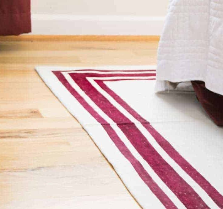 DIY area rug made from a canvas drop cloth and red fabric paint