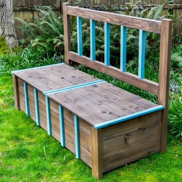 DIY outdoor storage bench on grass with ferns in background