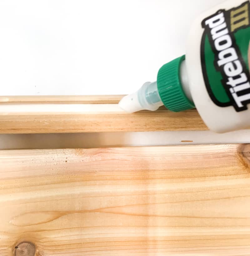 applying wood glue to groove of tongue and groove board