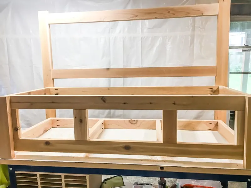 attaching the front legs to the frame of the outdoor storage bench