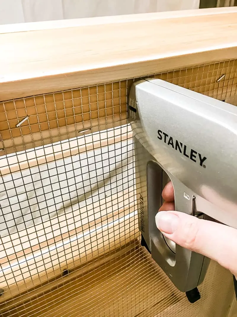 stapling wire mesh to underside of an outdoor storage bench