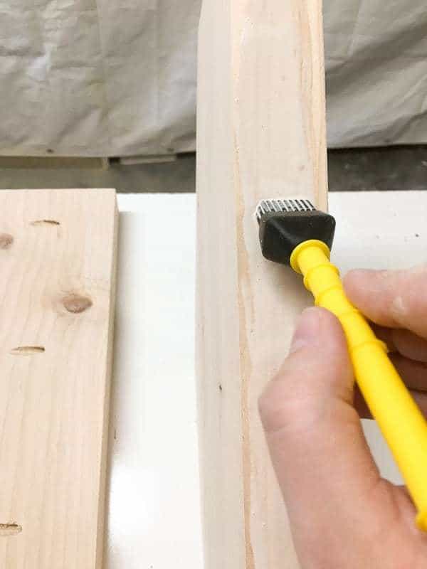 applying wood glue to board edge with a brush