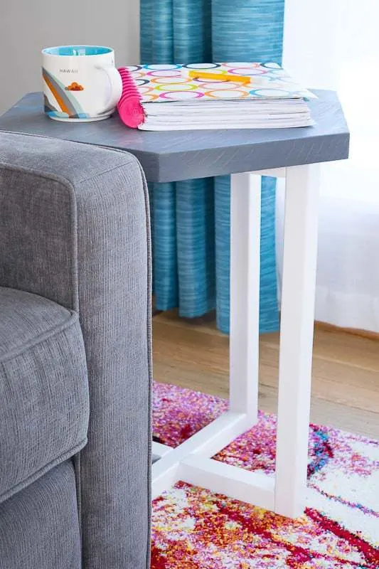 DIY hexagon end table next to couch with coffee cup and planner on top