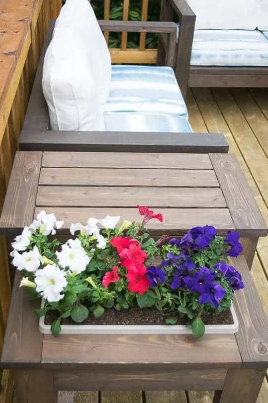 DIY end table with planter box full of white, red and purple flowers