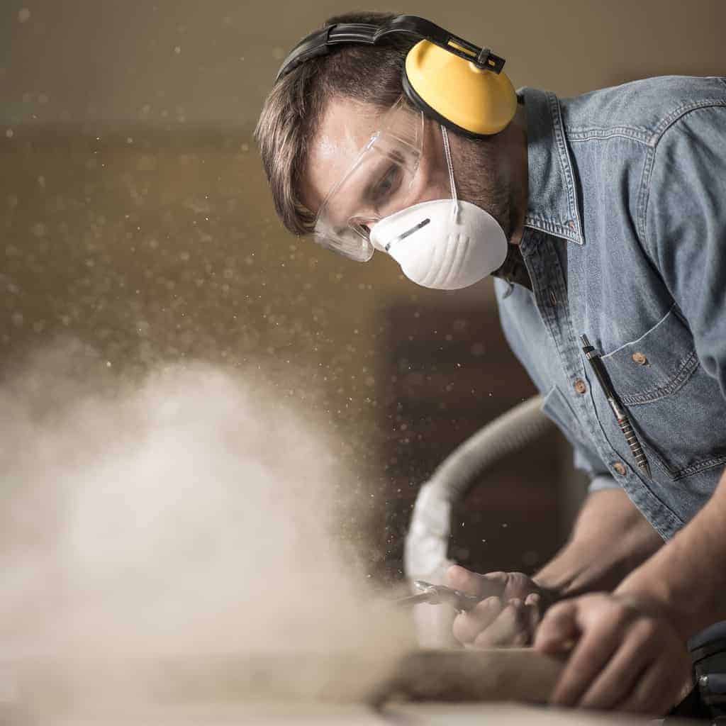 woodworker creating a cloud of sawdust
