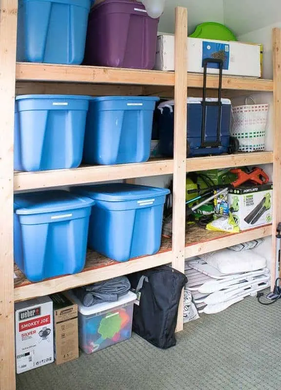 plastic bins and outdoor equipment stored on shed shelving