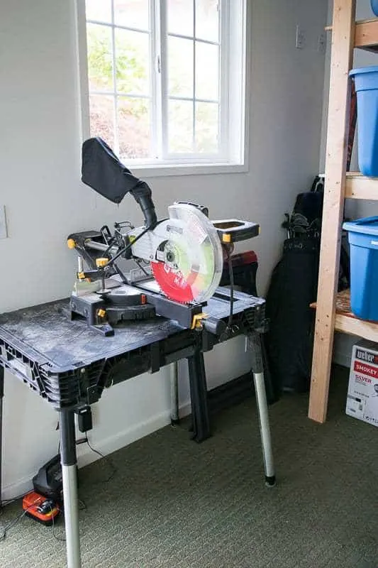 miter saw and stand with shed shelving in background