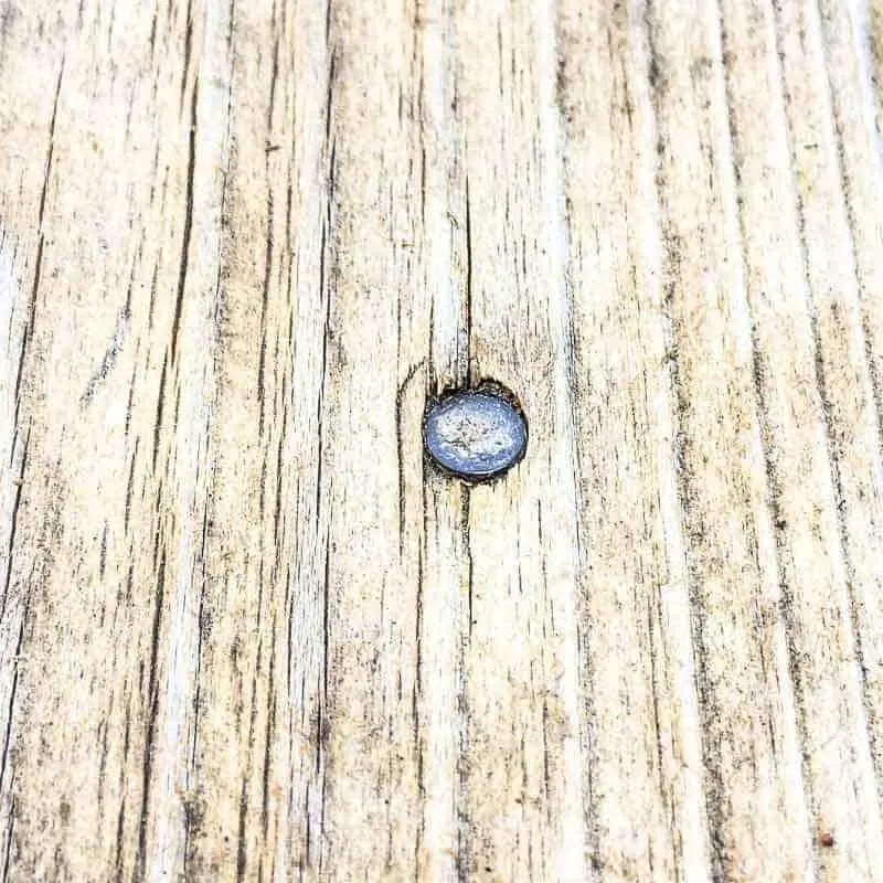 nail head in cedar deck below the surface of the wood