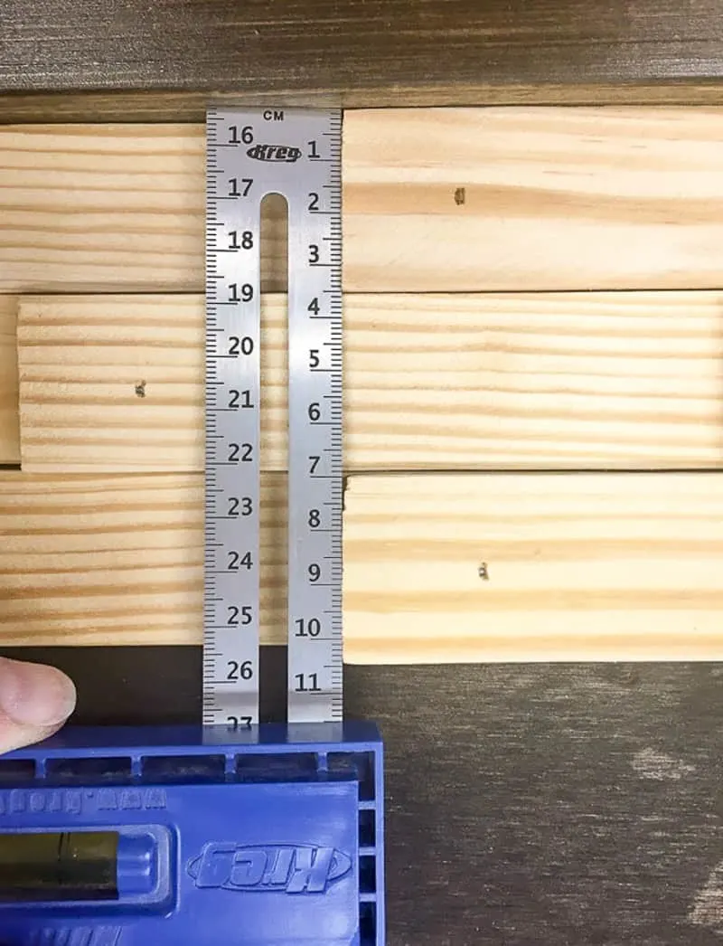 using a Kreg Multi Mark to line up ends of wood shims on DIY sliding barn door