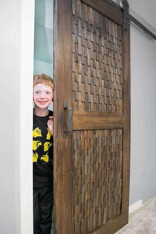 DIY barn door slightly open with little boy peeking out