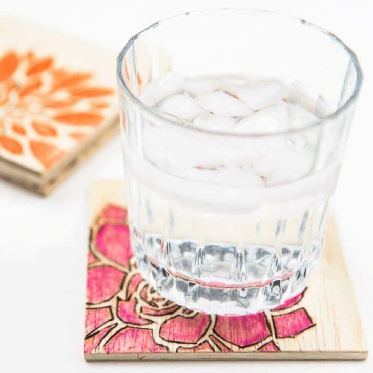 watercolor wood burned coasters with ice water