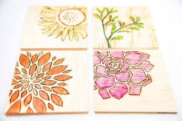 set of four DIY wood burned coasters with botanical designs