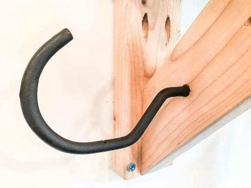 extra large bike hook screwed into garden tool storage rack