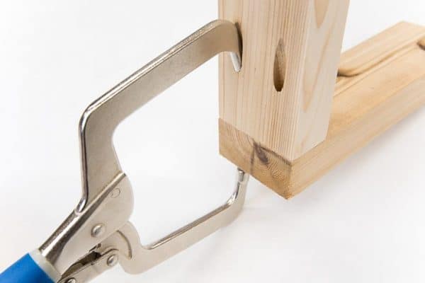 Kreg right angle clamp holding two pieces of wood together at the pocket holes