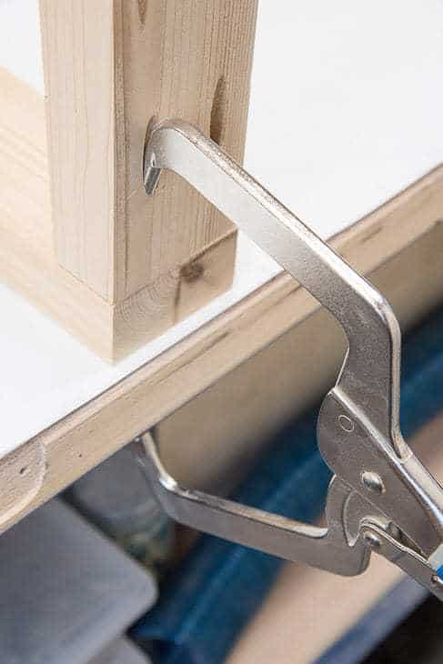 Two boards joined together with a right angle clamp in the pocket hole.