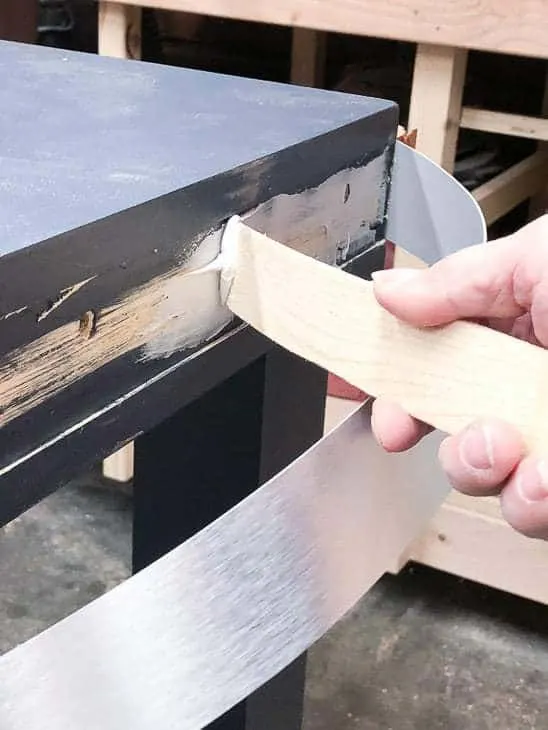 Use construction adhesive to attach the metal banding to the desk.