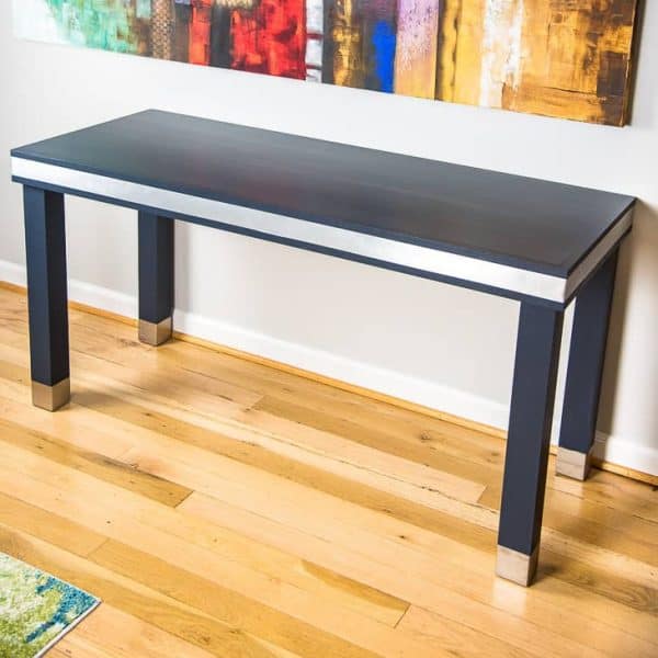 The navy blue paint contrasts beautifully with the brushed aluminum accents of this wood and metal desk.