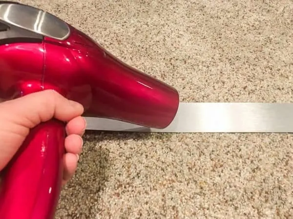 Use a hair dryer to help the metal banding relax and flatten out.