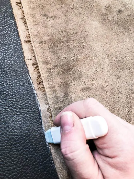 piece of fabric being traced with a chalk wheel on leather