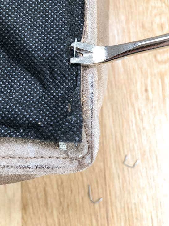 DIY ottoman cushion with staples being removed