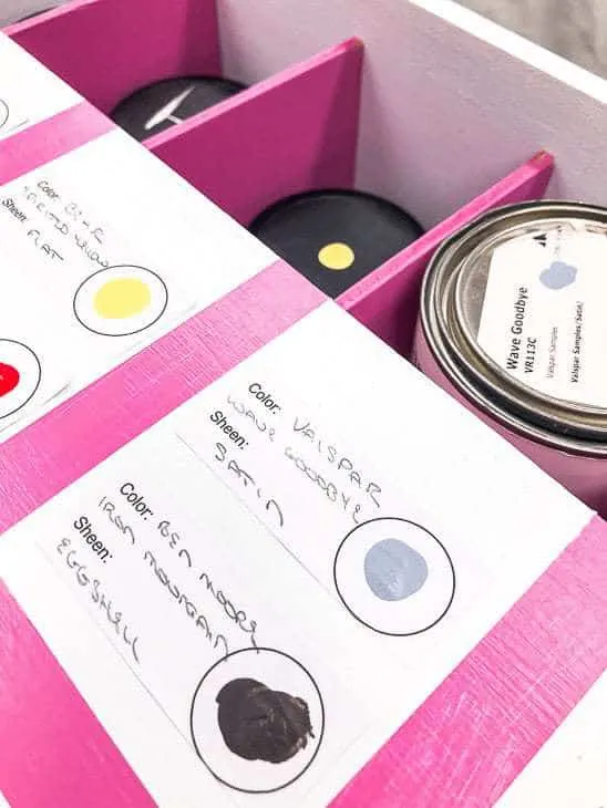 white box with pink box dividers holding paint samples, with labels on the lid