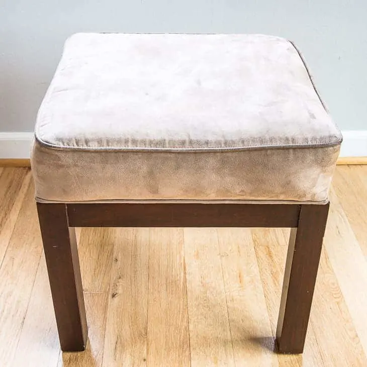 tan ottoman with dark brown wood base