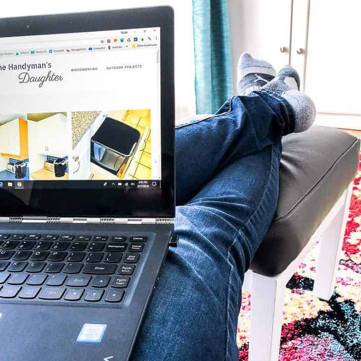 feet propped up on a leather ottoman with laptop