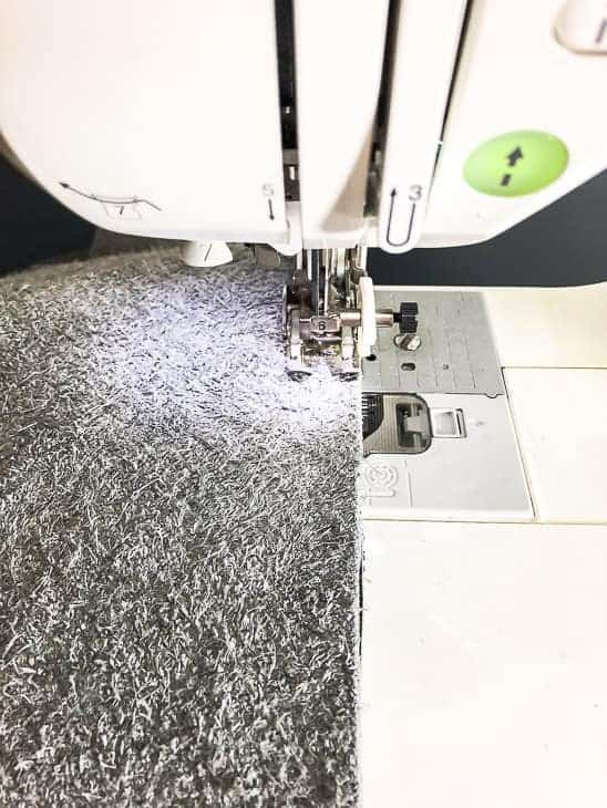 leather DIY ottoman cover being sewn