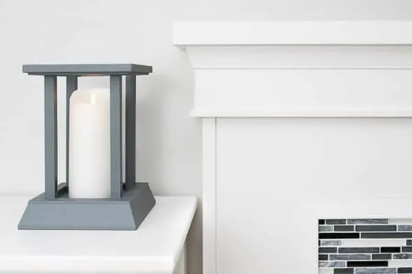 DIY candle lantern next to fireplace mantel