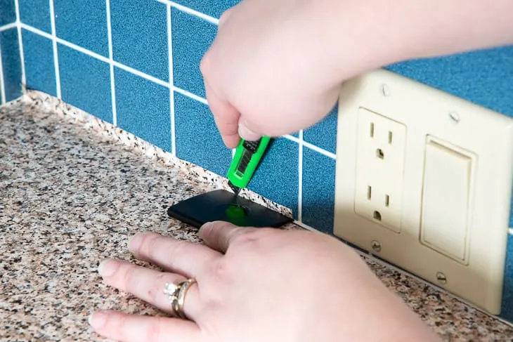 trimming excess countertop contact paper along wall